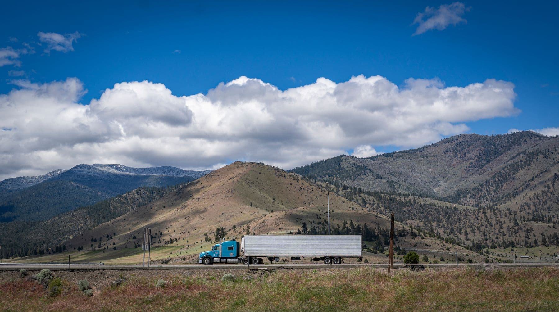 A semi truck travelling along an open American highway